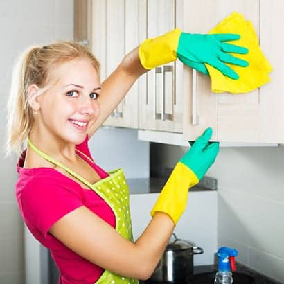 Employee Cleaning outside of a kitchen cabinet