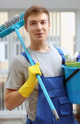young Male Spring Fresh Employee Broom over Shoulder and Bucket in his other hand